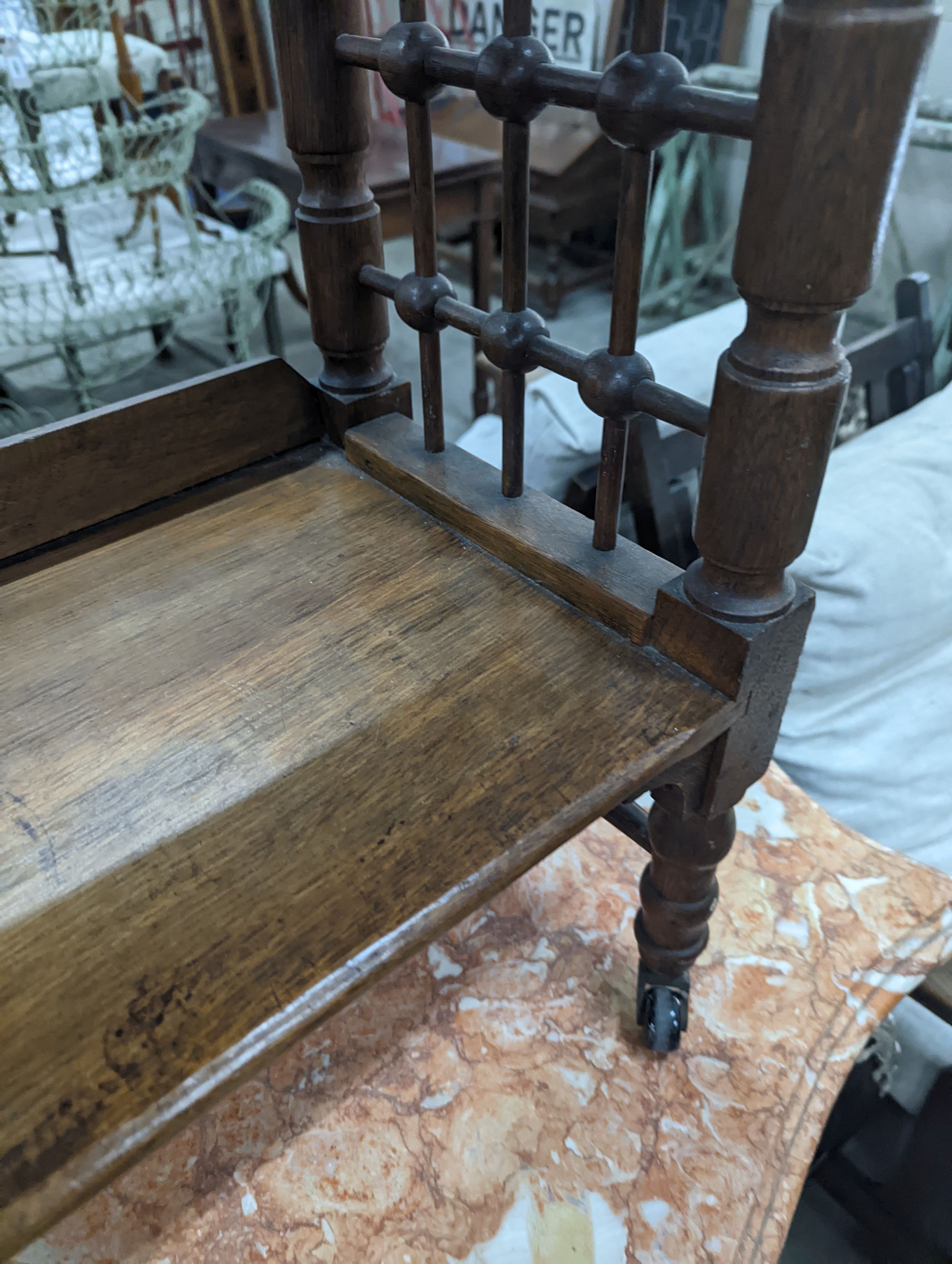 A late 19th century Continental oak three tier Liberty style table with slant top, width 70cm, depth 29cm, height 78cm